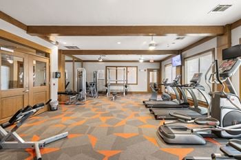 A gym with treadmills and other exercise equipment in a room